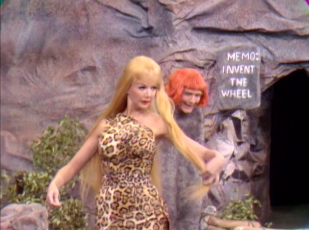 Cavewoman Chanin Hale flirts with caveman Red Skelton - note the memo to invent the wheel in the background - in "Bratman"
