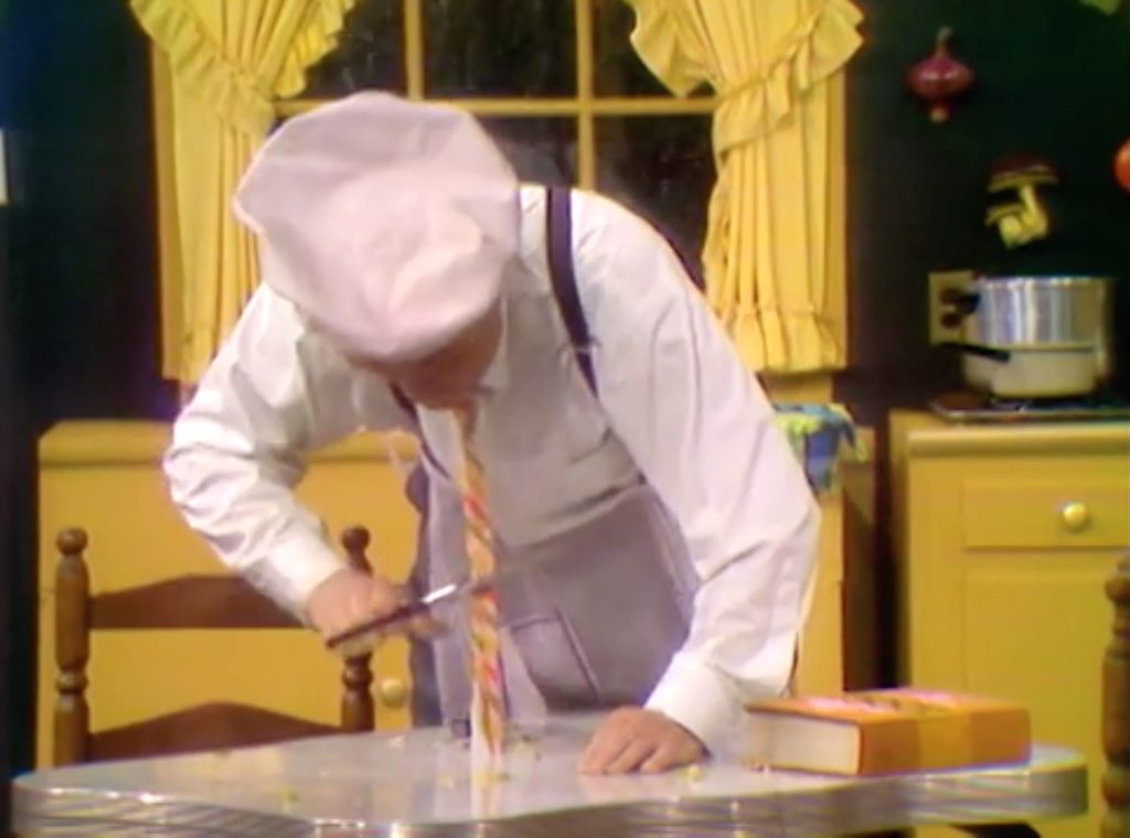 Red gets his tie caught in the sliding table, and cuts himself free
