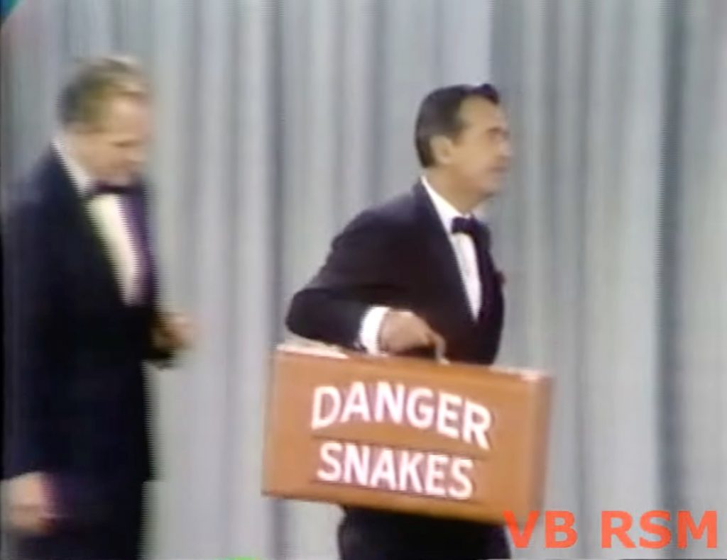 Red Skelton looks on at Tennessee Ernie Ford's snake bite kit