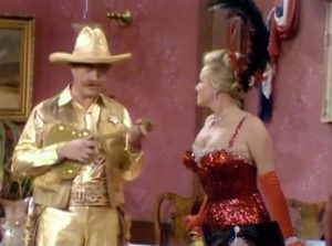 Sheriff Deadeye, in his expensive gold suit, with the pretty saloon girl in "The Best Sheriff Money Can Buy"