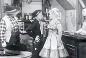 "I'm going to enjoy working with you, Sheriff" Deadeye and the bartender looks on as Mr. Pallid mistakes Kate for the Sheriff -- and kisses her!