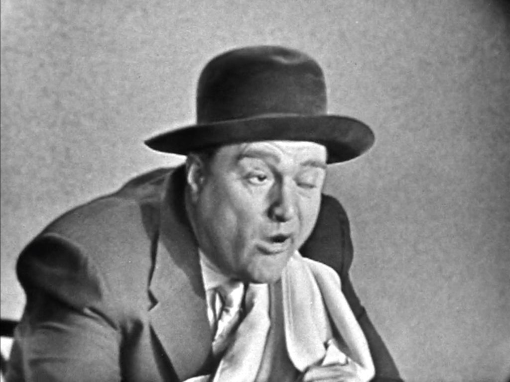 As part of his dunking donuts routine, Red Skelton demonstrates how different people are at breakfast -- here, sleepy