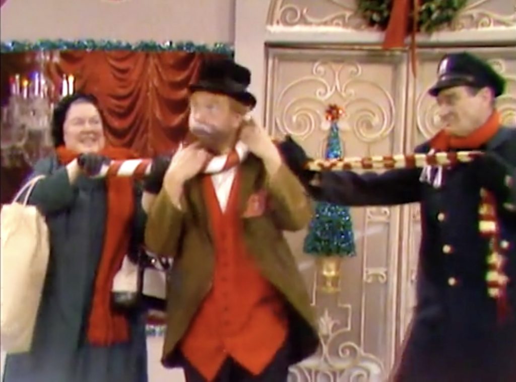 Peggy Rea and Officer Ray Kellogg do tug of war, with Freddie the Freeloader in the middle in "The Christmas Spirit"
