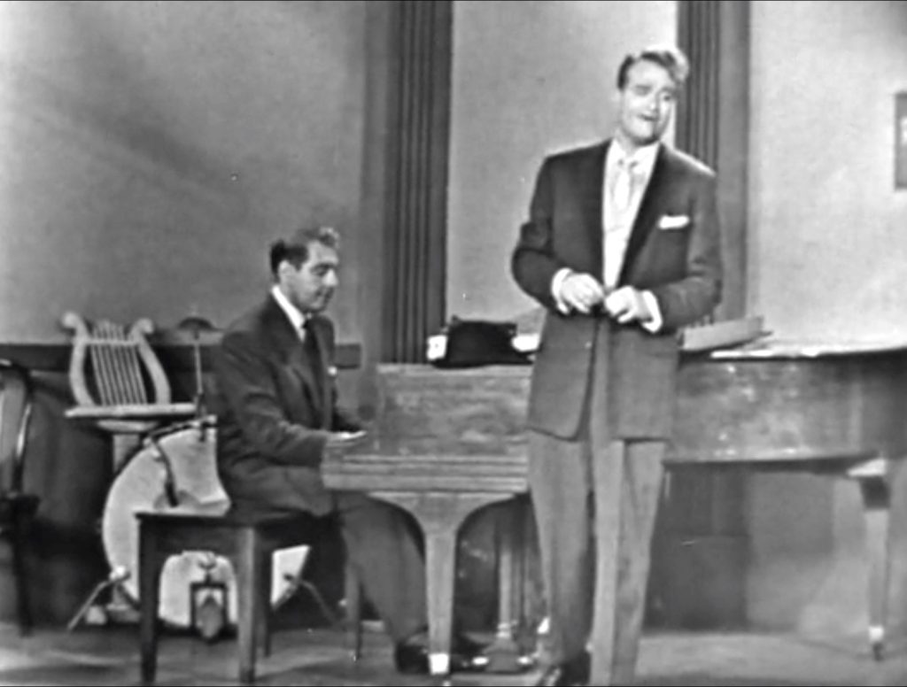 George Appleby manages to sing "Foggy Foggy Dew" -- before he realizes that it's David Rose at the piano!