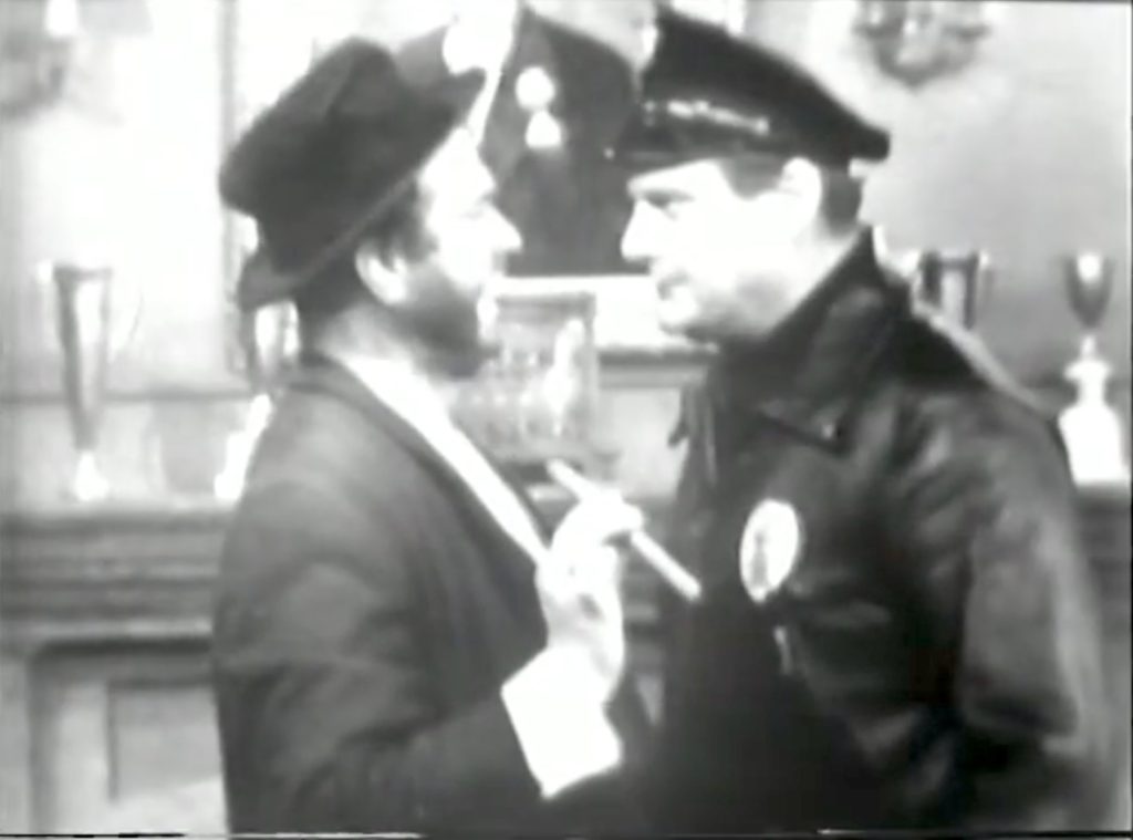 Freddie the Freeloader confronted by the cop (Ray Kellogg) who doesn't *believe* that he's the millionaire Mr. Van Horn!