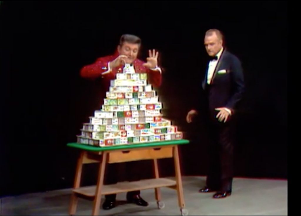In the One Minute Drama, Liberace is building a house of cards - that Red intends to blow over!