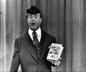 Clem Kadiddlehopper trying to sell a book about hiccups in The Red Skelton Show episode, "The Railroad Station"