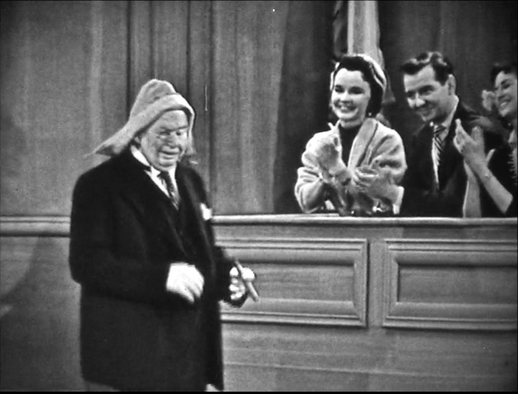 Charles Coburn enters the courtroom to applause - wearing a towel over his bad haircut!