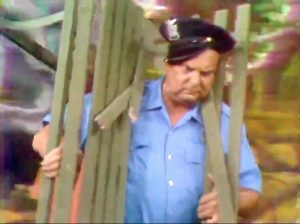 Police officer (Jackie Coogan) unintentionally hit by Freddie's park bench in "Hippie Days are Here Again"