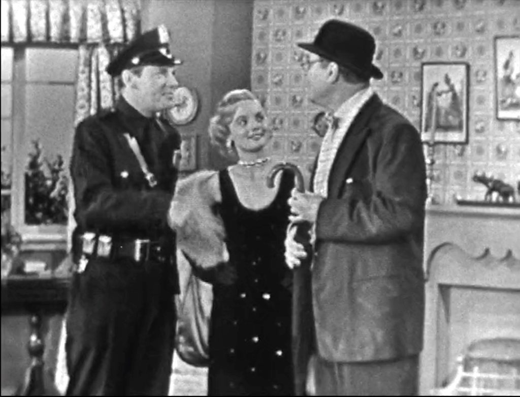 Police officer, damsel Adele Jergens, and triumphant George Appleby