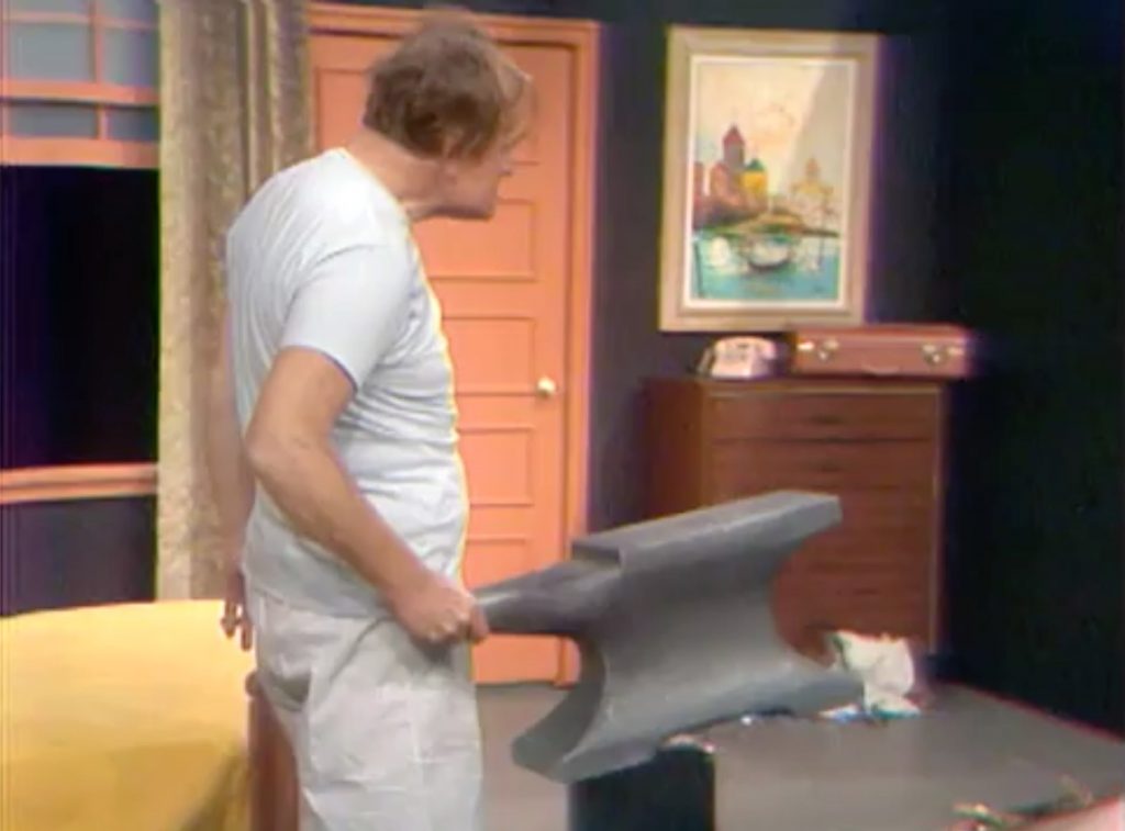 Tired Red Skelton carrying an anvil as a weapon