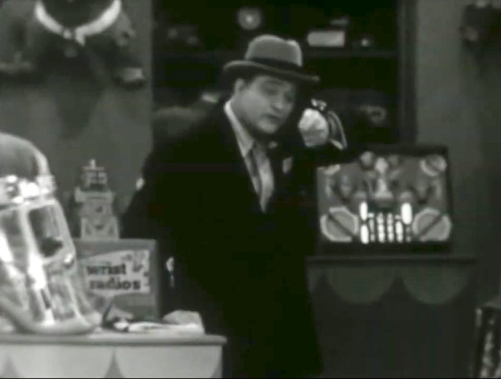 Red Skelton testing the wrist radio at the store
