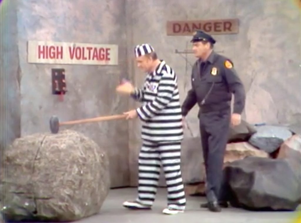 Convict Red Skelton on the rock pile, as guard Ray Kellogg watches in The Silent Spot