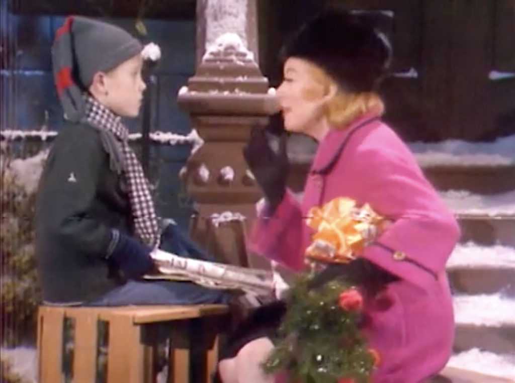 In a sketch, Greer Garson tells a young newspaper boy about the Christmas spirit