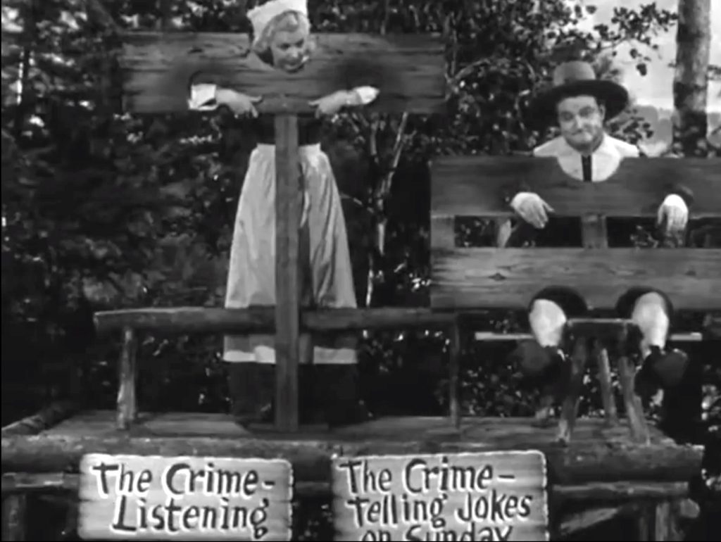 Lucille Knoch and Red Skelton as pilgrims in stocks in "Weepy Talks Turkey"