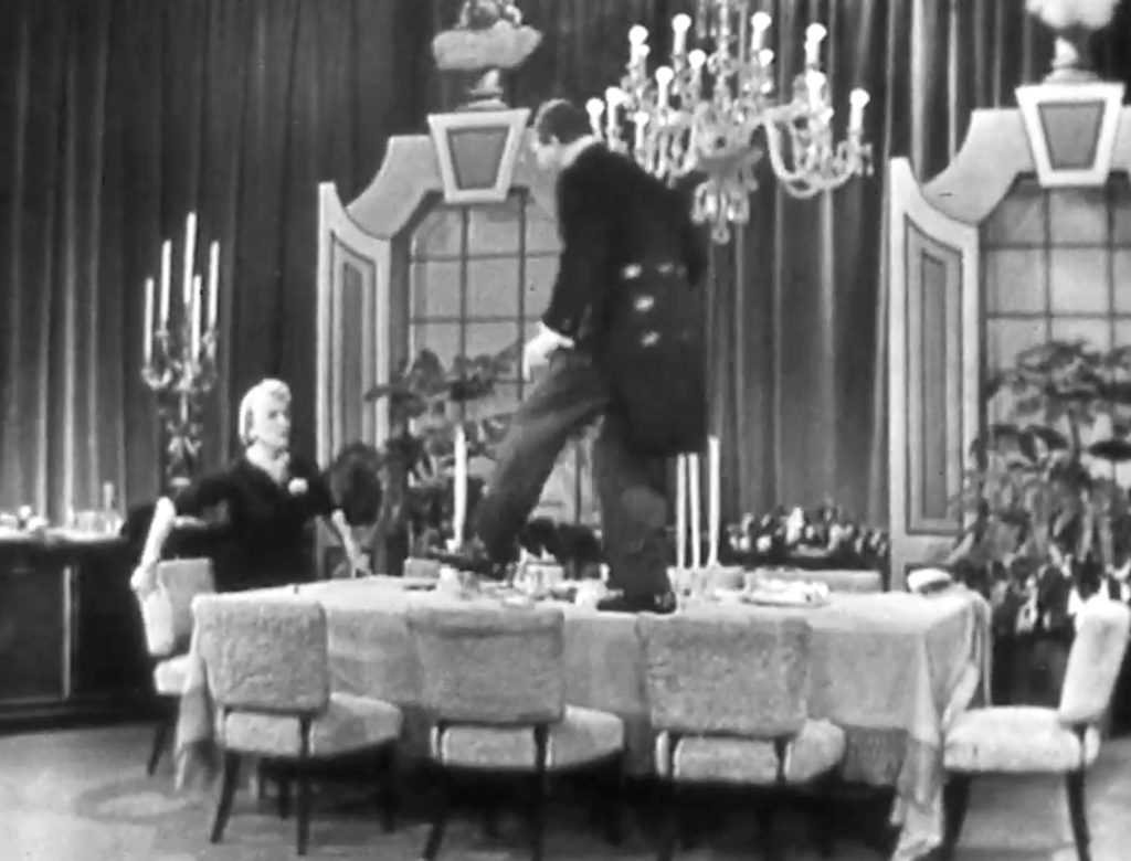 Clem Kaadiddlehopper as an inept butler walking across Cobina Wright's table