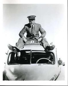 Publicity photo for The Yellow Cab Man - Red Skelton sitting on top of a yellow cab